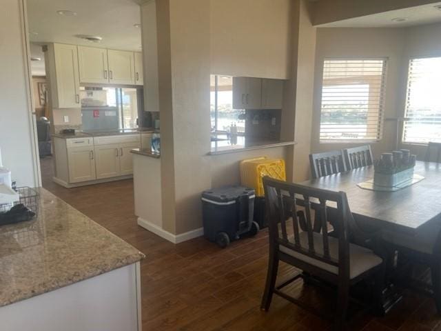 dining space featuring dark wood finished floors and baseboards