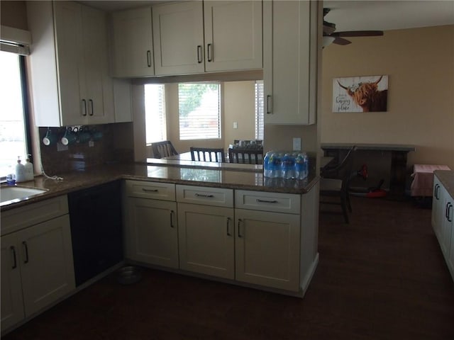 kitchen with a ceiling fan, a sink, white cabinetry, decorative backsplash, and dark wood-type flooring