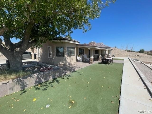 back of house with a patio area and stucco siding