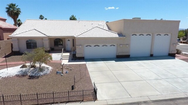 2084 E Crystal Dr, Fort Mohave, AZ 86426 - view of front of house with fence, stucco siding, a tiled roof, an attached garage, and driveway
