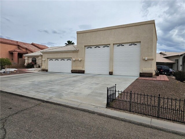 2084 E Crystal Dr, Fort Mohave, AZ 86426 - view of front facade with stucco siding, fence, an attached garage, concrete driveway, and a tile roof