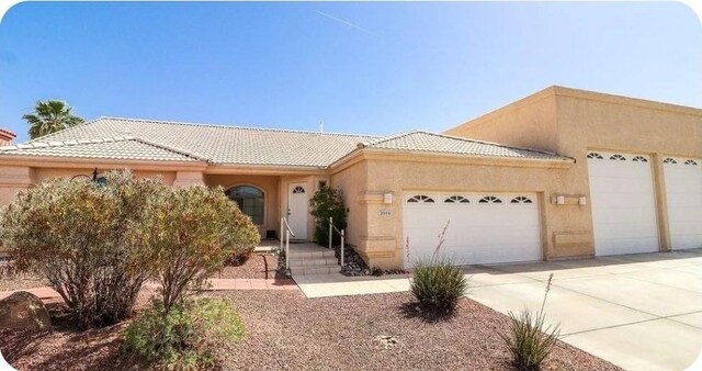2084 E Crystal Dr, Fort Mohave, AZ 86426 - view of front of property with a tile roof, stucco siding, concrete driveway, and an attached garage