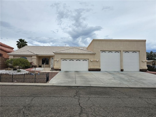 2084 E Crystal Dr, Fort Mohave, AZ 86426 - view of front of home with driveway, an attached garage, stucco siding, fence, and a tile roof