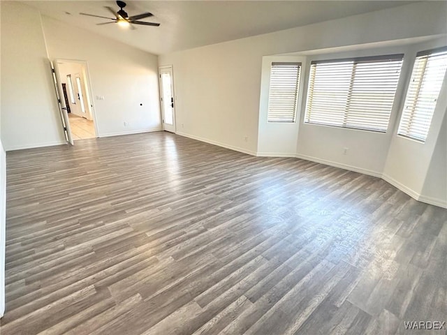 spare room with lofted ceiling, baseboards, a ceiling fan, and wood finished floors