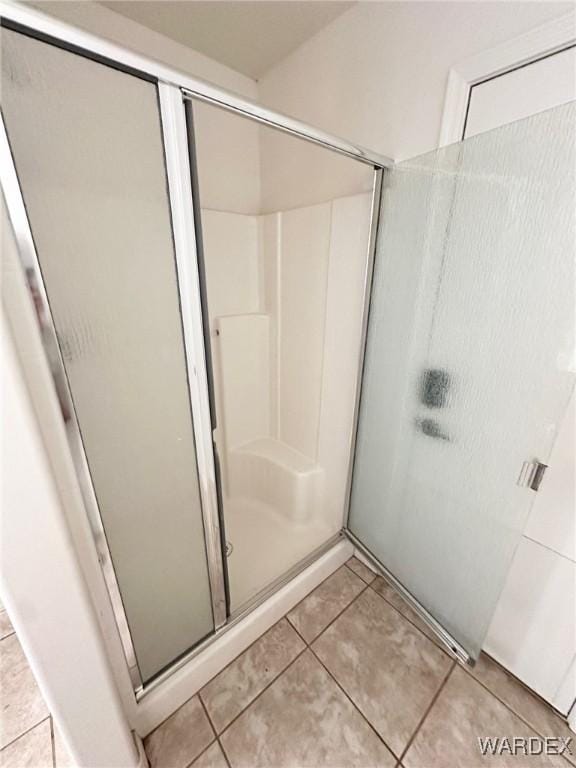bathroom with tile patterned flooring and a shower stall
