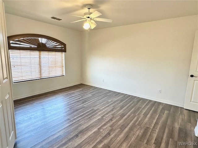 spare room with ceiling fan, baseboards, dark wood-type flooring, and visible vents