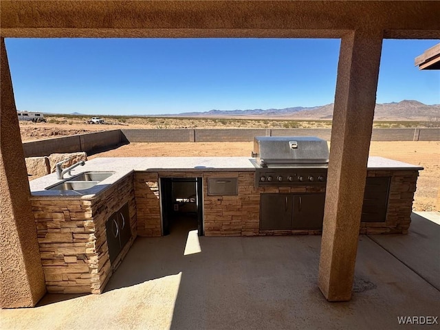 view of patio featuring a mountain view, a grill, a sink, and area for grilling