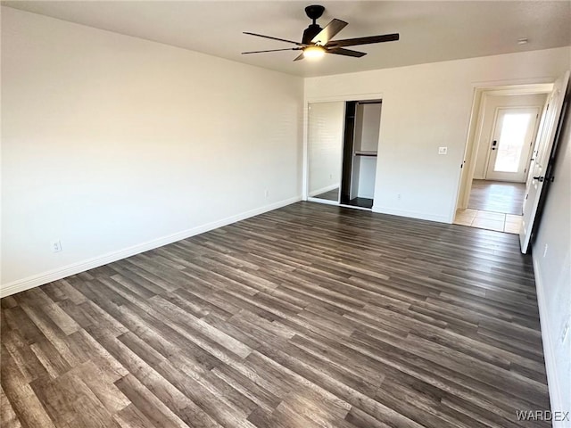 unfurnished bedroom featuring dark wood finished floors, a closet, and baseboards