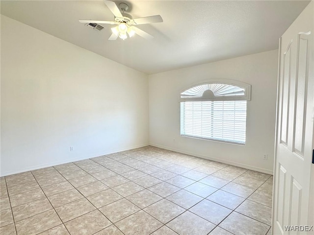 spare room featuring ceiling fan, baseboards, light tile patterned flooring, and visible vents