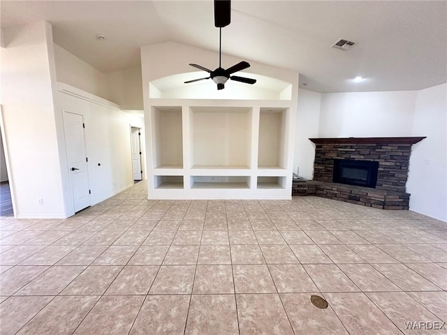 unfurnished living room featuring a stone fireplace, light tile patterned floors, ceiling fan, lofted ceiling, and visible vents