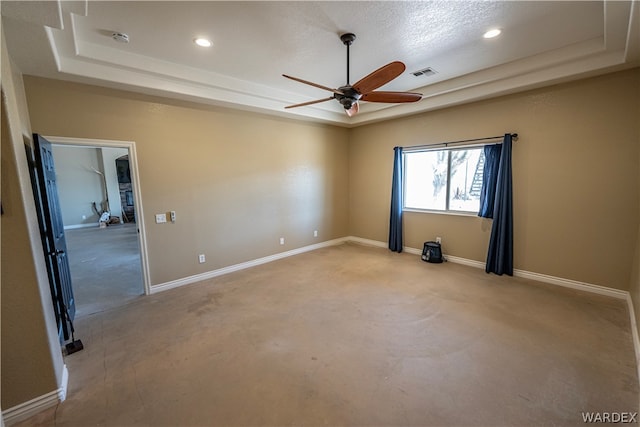 unfurnished room featuring a tray ceiling, visible vents, baseboards, and recessed lighting