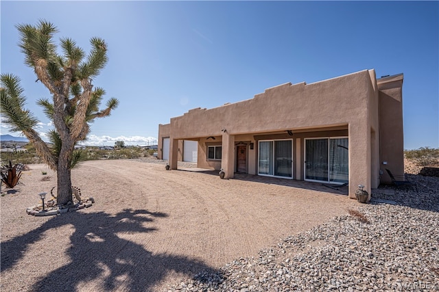 rear view of property with stucco siding