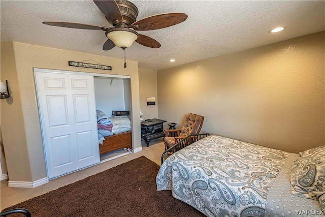 bedroom with light carpet, a ceiling fan, a textured ceiling, a closet, and recessed lighting