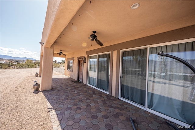 view of patio / terrace with ceiling fan and a mountain view