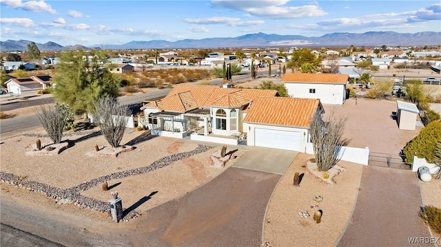 view of front of house featuring a residential view, a mountain view, driveway, and an attached garage