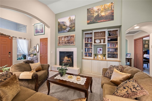 3854 Heather Ave, Kingman, AZ 86401 - living room featuring arched walkways, a fireplace, carpet flooring, and high vaulted ceiling