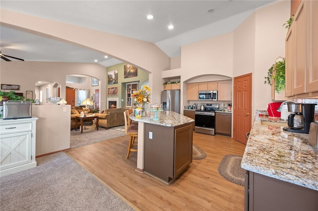 3854 Heather Ave, Kingman, AZ 86401 - kitchen with appliances with stainless steel finishes, open floor plan, arched walkways, a center island, and a breakfast bar