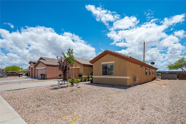 3854 Heather Ave, Kingman, AZ 86401 - view of front of home with stucco siding, a tile roof, a garage, and driveway