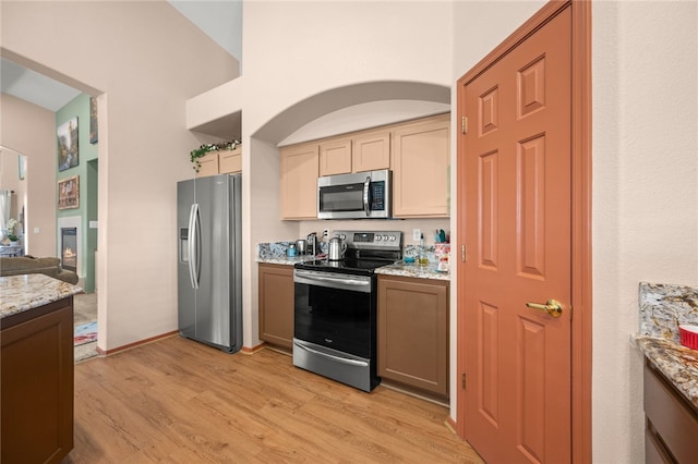 3854 Heather Ave, Kingman, AZ 86401 - kitchen with appliances with stainless steel finishes, light wood-style flooring, light stone countertops, arched walkways, and a high ceiling