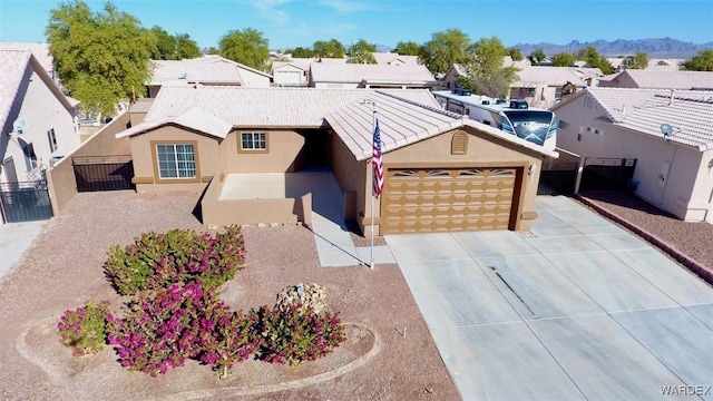 ranch-style home featuring concrete driveway, a residential view, fence, a mountain view, and stucco siding