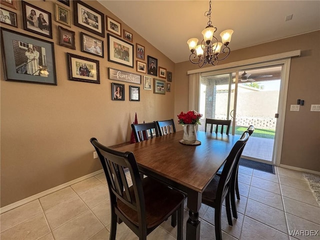 dining space featuring lofted ceiling, light tile patterned floors, a notable chandelier, and baseboards