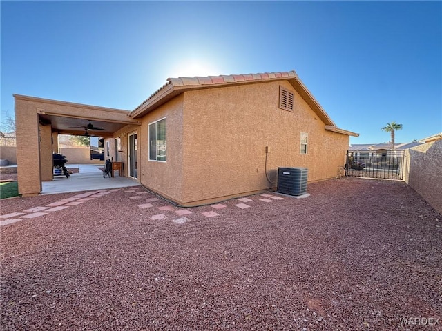 view of home's exterior featuring a patio, stucco siding, a ceiling fan, central AC, and fence