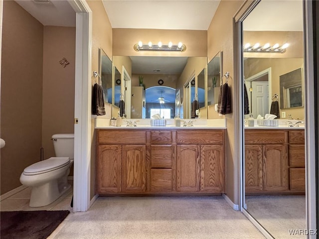 bathroom featuring double vanity, a sink, and toilet