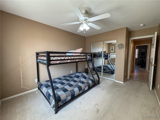 bedroom with ceiling fan, carpet floors, a closet, and baseboards