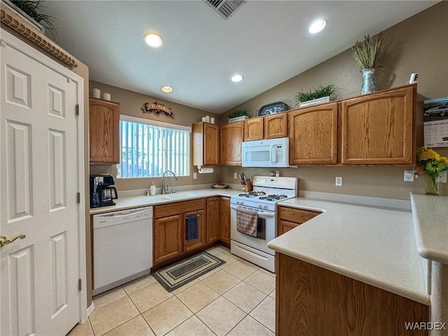 kitchen with brown cabinets, light countertops, light tile patterned flooring, a sink, and white appliances