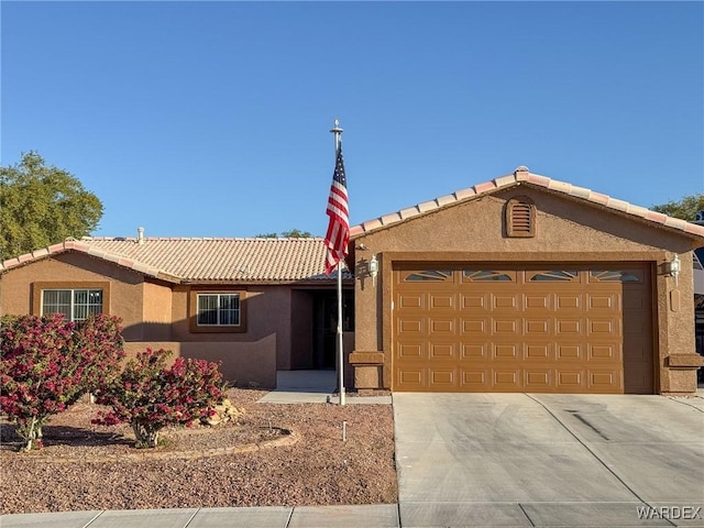 ranch-style home with a garage, a tile roof, concrete driveway, and stucco siding