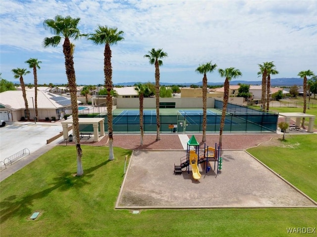 surrounding community with playground community, a tennis court, a lawn, and fence