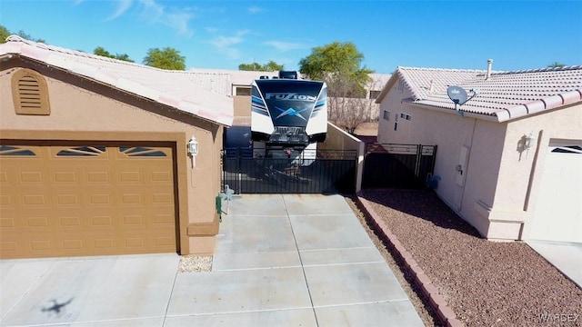 view of home's exterior featuring a garage, a tile roof, and stucco siding