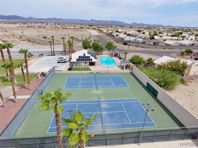 view of sport court featuring fence and a mountain view