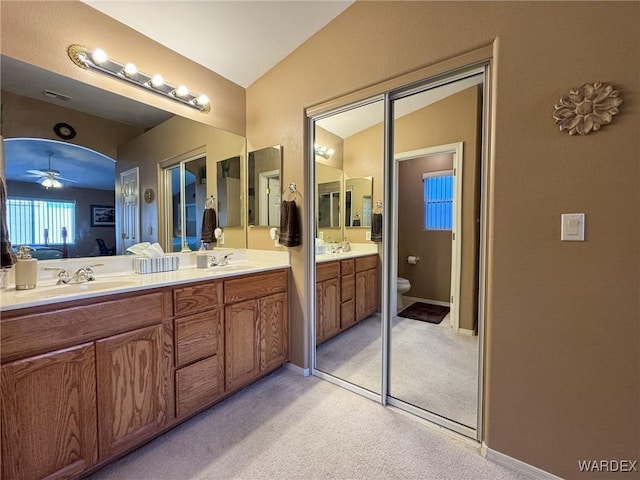 bathroom featuring visible vents, a sink, toilet, and double vanity