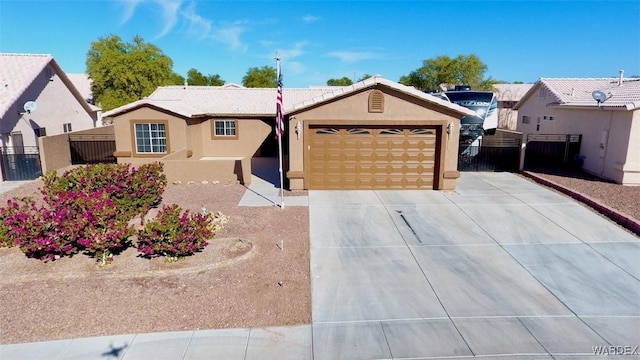 ranch-style house featuring a garage, driveway, fence, and stucco siding