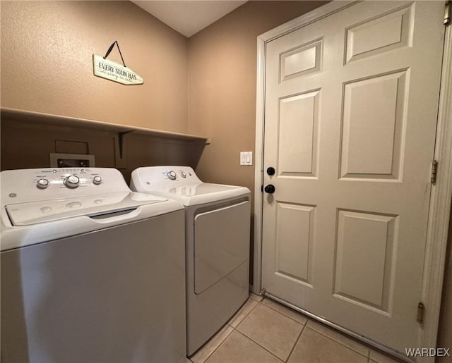 laundry area featuring laundry area, light tile patterned floors, and separate washer and dryer