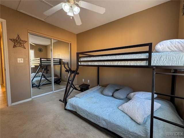 bedroom featuring a ceiling fan, carpet, a closet, and baseboards