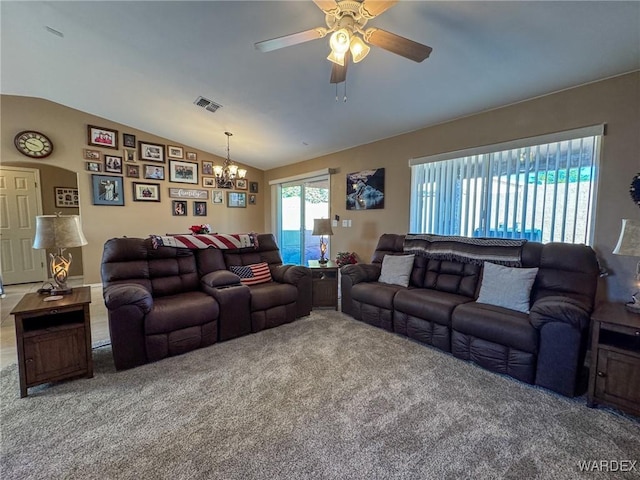 living area featuring carpet floors, visible vents, vaulted ceiling, and ceiling fan with notable chandelier