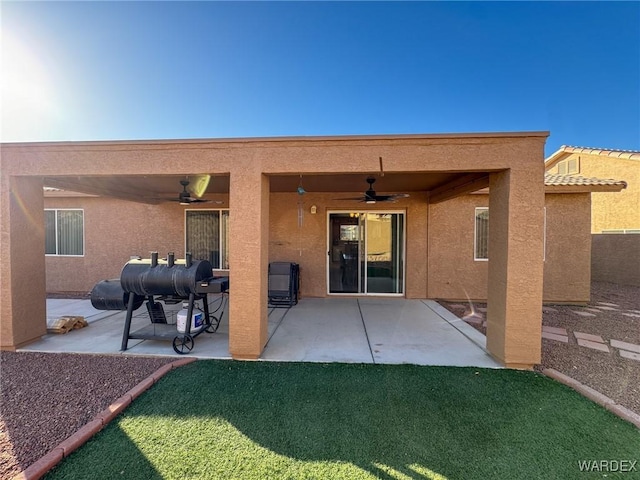 back of house featuring stucco siding, a yard, a ceiling fan, and a patio