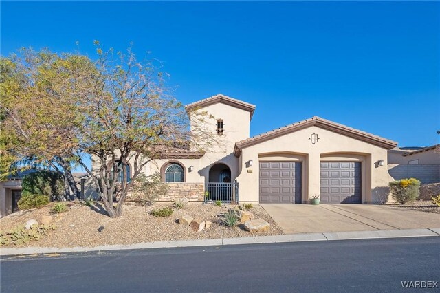 mediterranean / spanish-style home featuring a tile roof, stucco siding, a garage, stone siding, and driveway