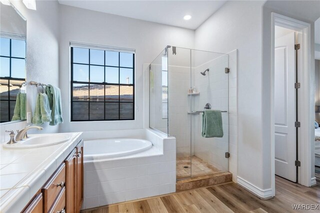 bathroom featuring recessed lighting, a shower stall, vanity, wood finished floors, and a bath