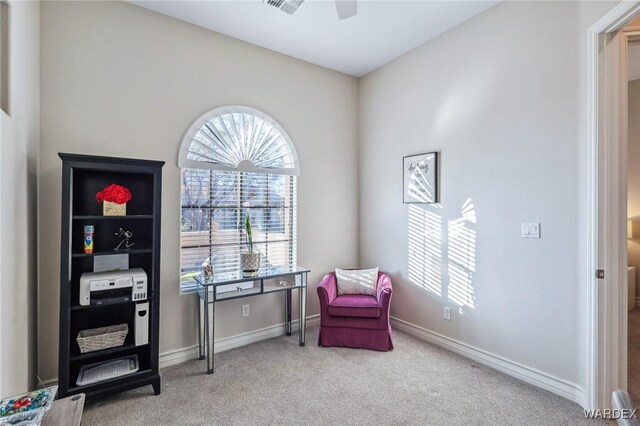 living area with carpet, baseboards, and ceiling fan