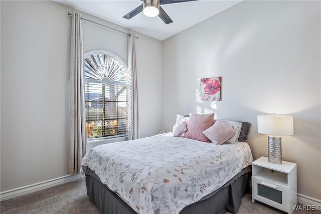 bedroom featuring baseboards, dark colored carpet, and a ceiling fan