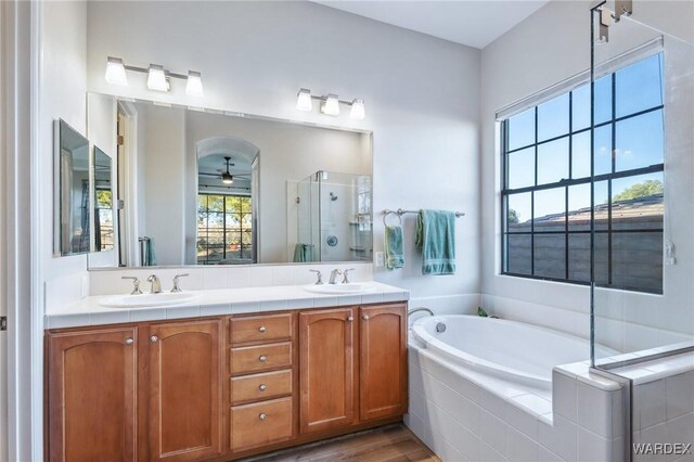 full bathroom with a garden tub, a sink, a shower stall, and double vanity