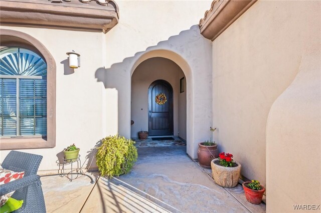 doorway to property featuring a patio area and stucco siding