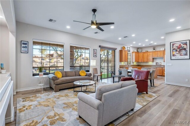 living area featuring recessed lighting, visible vents, light wood-style flooring, a ceiling fan, and baseboards