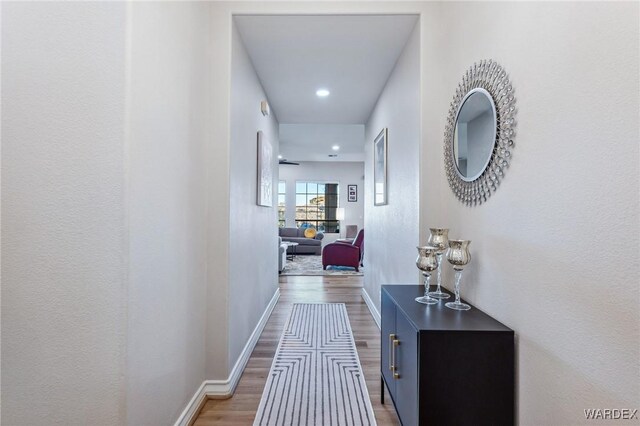 hall with wood finished floors and baseboards