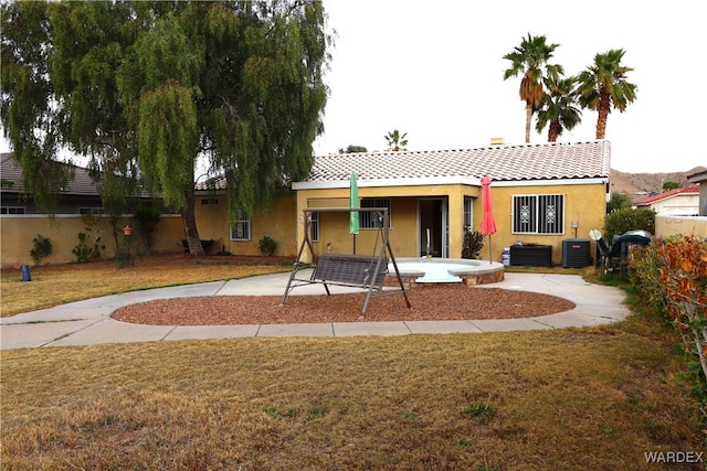 rear view of house with a yard, a patio area, fence, and stucco siding