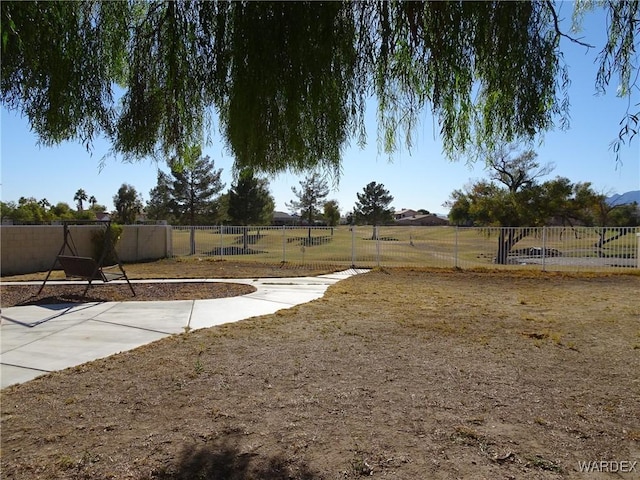 view of yard with fence and a rural view