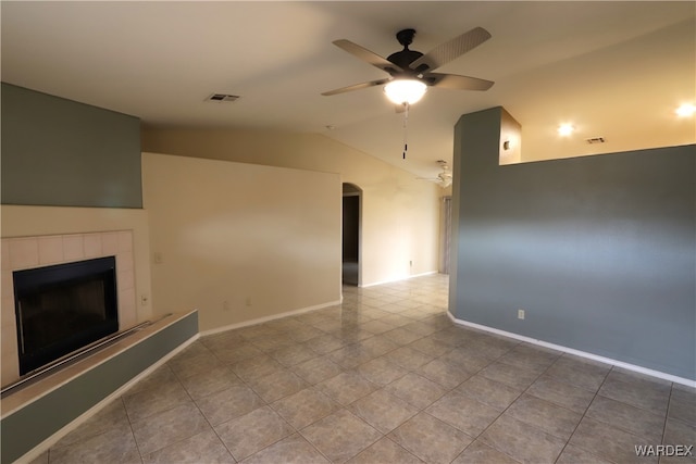 unfurnished living room with lofted ceiling, tile patterned flooring, a tile fireplace, visible vents, and a ceiling fan